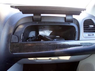 Unsecured firearm in car glove compartment.